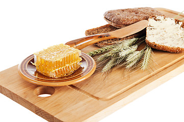 Image showing honey, spike and bread on table 