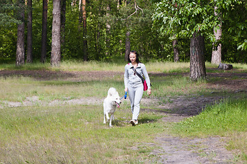 Image showing The young woman walks in park with a dog