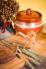 Image showing sliced bread and wheat on the wooden table 