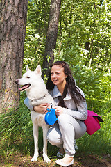 Image showing The young woman with a white dog on the nature