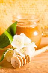 Image showing jar of honey on the background of honeycombs 