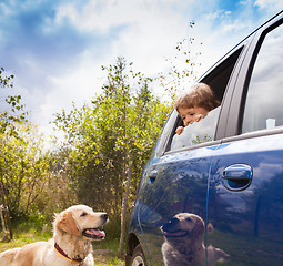 Image showing kid and dog look at each other