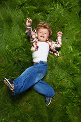 Image showing laughing boy rolling on grass