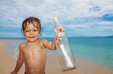 Image showing kid found sos bottle in the sea