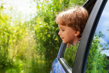 Image showing curious kid looking outside of car window