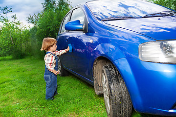 Image showing adorable child helping to wash car