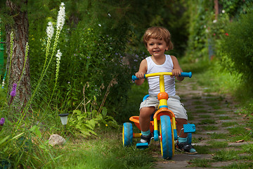 Image showing little boy riding tricycle