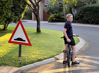 Image showing Young Boy Stopped Bicycle at Speed Bump