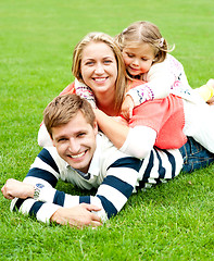 Image showing Young mother sandwiched between her daughter and husband