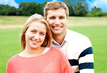 Image showing Young man standing behind his wife and hugging