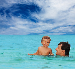Image showing dad and son swimming together