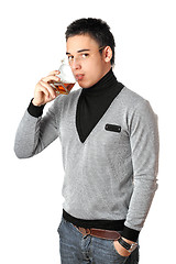 Image showing Young man drinking whiskey from a glass. Isolated