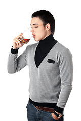 Image showing Young man drinking whiskey from a glass