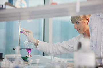 Image showing female researcher holding up a test tube in lab