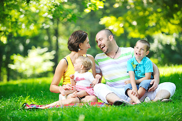 Image showing happy young couple with their children have fun at park