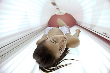 Image showing Beautiful young woman tanning in solarium