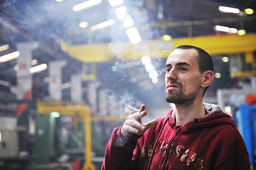 Image showing industry worker smoke cigarette