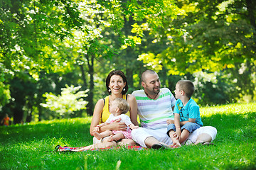 Image showing happy young couple with their children have fun at park