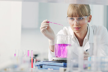 Image showing female researcher holding up a test tube in lab