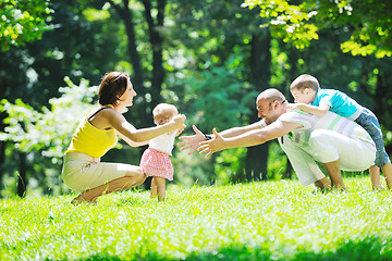 Image showing happy young couple with their children have fun at park