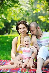 Image showing happy young couple with their children have fun at park