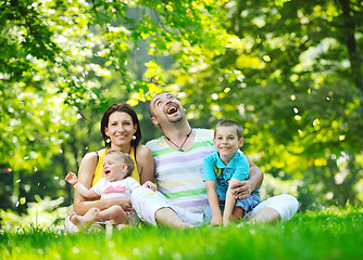 Image showing happy young couple with their children have fun at park