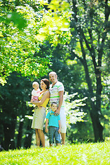 Image showing happy young couple with their children have fun at park