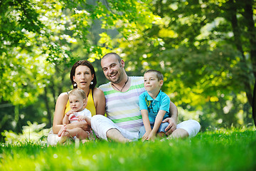 Image showing happy young couple with their children have fun at park