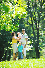 Image showing happy young couple with their children have fun at park