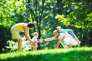 Image showing happy young couple with their children have fun at park