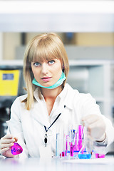 Image showing female researcher holding up a test tube in lab