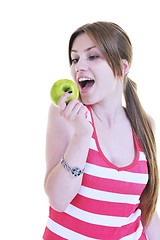 Image showing happy  young  woman eat green apple isolated  on white