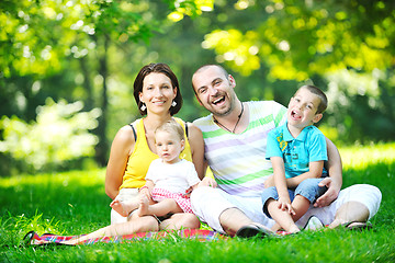 Image showing happy young couple with their children have fun at park