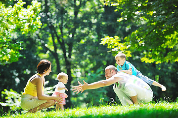 Image showing happy young couple with their children have fun at park