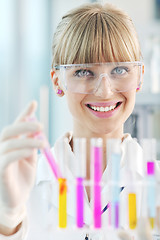 Image showing female researcher holding up a test tube in lab