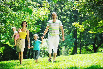 Image showing happy young couple with their children have fun at park