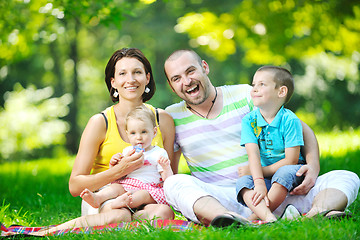 Image showing happy young couple with their children have fun at park