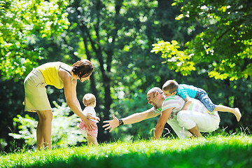 Image showing happy young couple with their children have fun at park