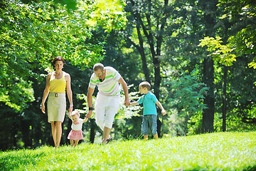 Image showing happy young couple with their children have fun at park