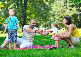 Image showing happy young couple with their children have fun at park