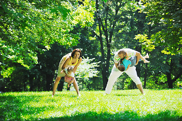 Image showing happy young couple with their children have fun at park