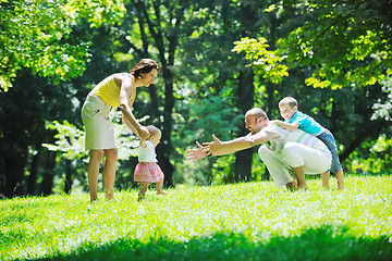 Image showing happy young couple with their children have fun at park