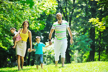 Image showing happy young couple with their children have fun at park