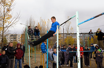 Image showing Young guys do exercises on the horizontal bar