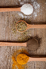 Image showing curry, pepper, oregano and cooking salt in wooden spoons