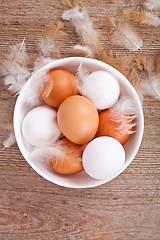 Image showing eggs and feathers on wooden table