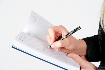 Image showing Woman writing in organizer