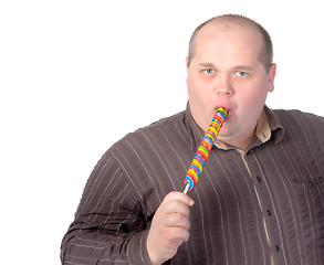 Image showing Fat man enjoying a lollipop