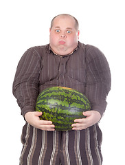 Image showing Fat man struggling to hold the weight of a whole watermelon