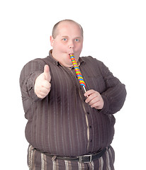 Image showing Fat man enjoying a lollipop